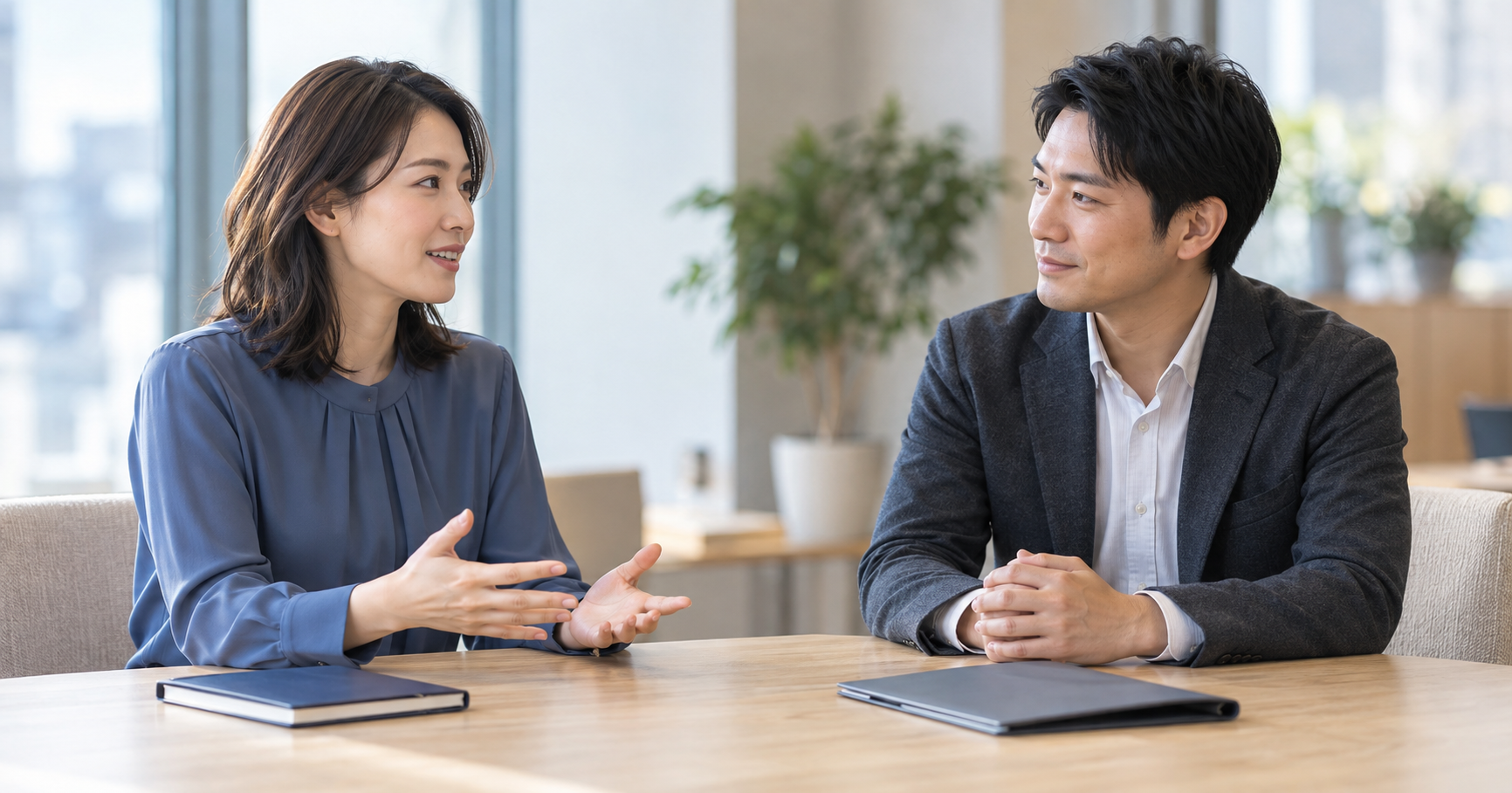 会議用のテーブルで、落ち着いて話す女性と耳を傾ける男性を描いた生成イメージ